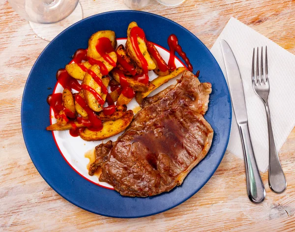 Veal entrecote with baked potatoes and tomato sauce — Stock Photo, Image