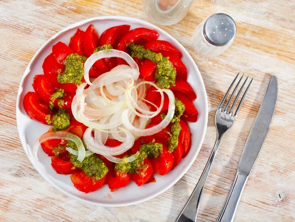 Frische Tomaten mit grüner Pesto-Sauce und Zwiebeln — Stockfoto