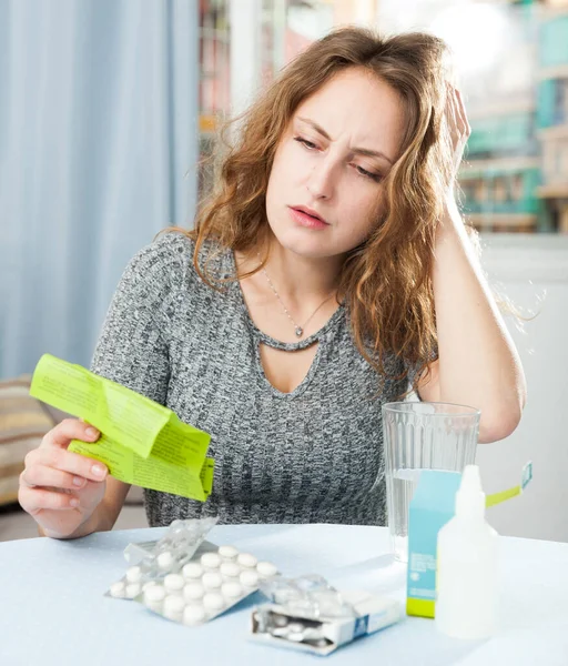 Разочарованная девушка принимает свои многочисленные таблетки — стоковое фото