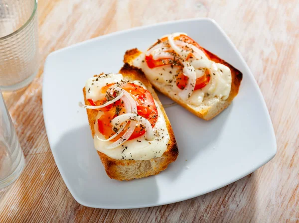 Peynirli, soğanlı ve domatesli kızarmış ekmek. — Stok fotoğraf
