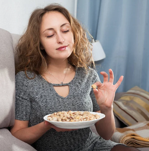 Woman holding plate of pistachios — Stock Photo, Image