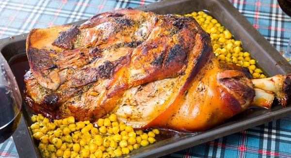 Tasty baked in oven pig ham with garbanzo at plate served — Stock Photo, Image