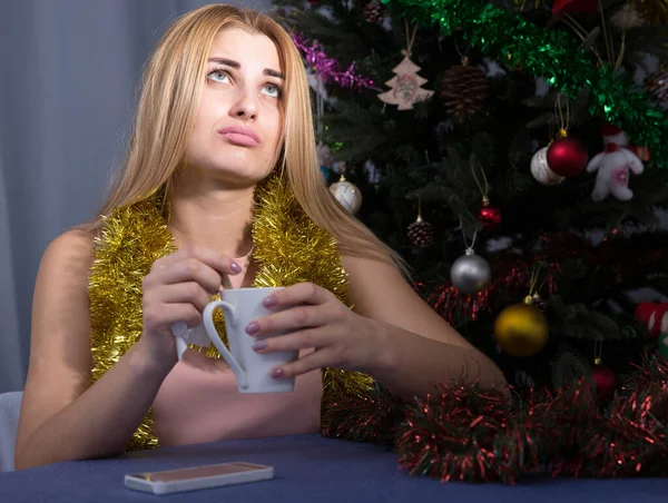 Traurige Frau langweilt sich in der Silvesternacht mit Tasse Tee — Stockfoto