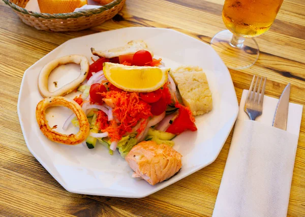 Grilled fish and squid rings with vegetable salad — Stock Photo, Image