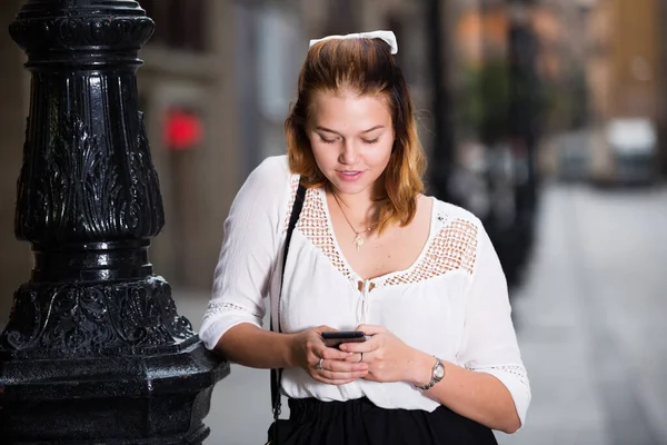 Cep telefonu kullanan gülümseyen kızın portresi — Stok fotoğraf