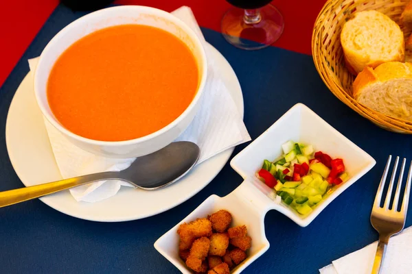 Kall soppa gazpacho i skål, serveras med bakade bröd och grönsaker — Stockfoto