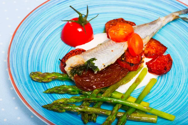 Pieczone ryby poutassou z suszonymi pomidorami, szparagami i sosem kremowo-czosnkowym — Zdjęcie stockowe