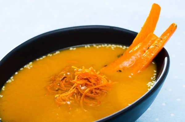 Sopa de creme de cenoura saborosa com cenoura servida na placa na mesa — Fotografia de Stock