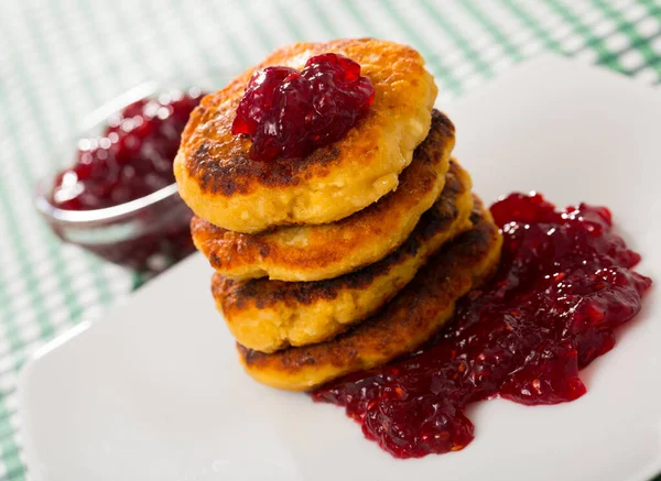 Stack of tasty fried quark pancakes served with berry jam — Stock Photo, Image