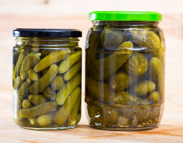 Glass jar with pickled cucumbers on wooden background — Stock Photo, Image