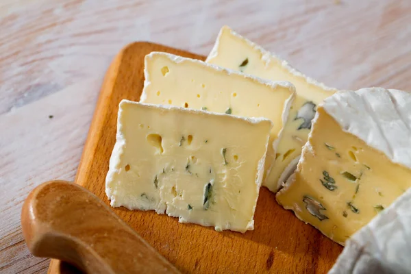 Leckere Scheiben Weichschimmelkäse mit blauem Schimmel auf Holzbrett — Stockfoto