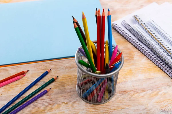 Lápices de madera multicolores en el escritorio con papeles y cuadernos —  Fotos de Stock