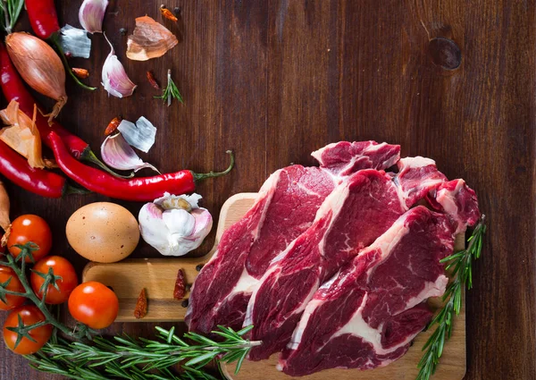 Surowa wołowina, warzywa na powierzchni drewnianej — Zdjęcie stockowe