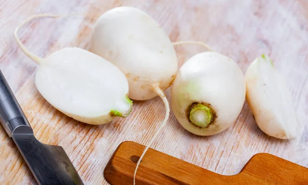 Couper navet blanc frais sur une table en bois dans la cuisine de la maison — Photo