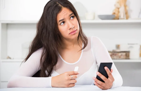 Upset young female with mobile phone — Stock Photo, Image