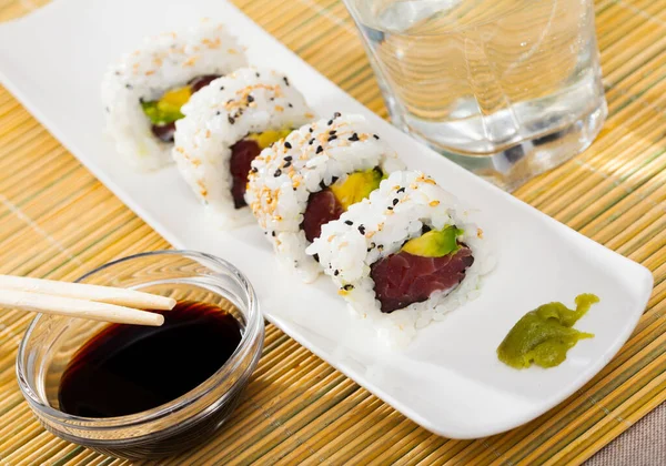 Delicious uramaki sushi with raw tuna at plate with soy sauce — Stock Photo, Image
