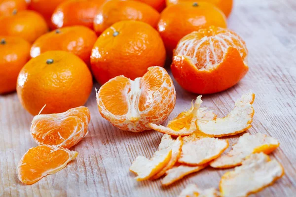 Closeup of fresh peeled clementines on wooden table — Stock Photo, Image