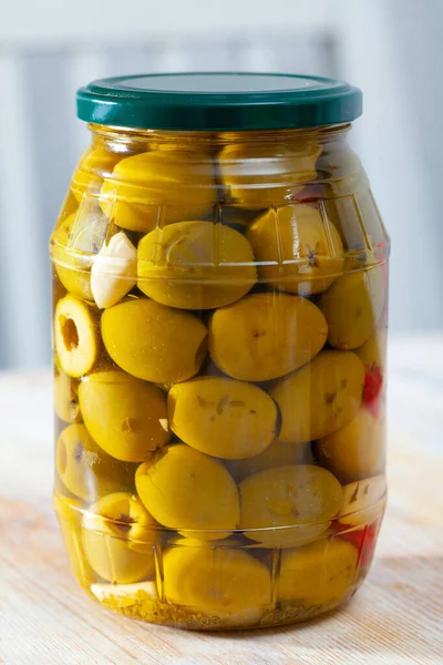 Glass jar with delicious whole olives at wooden table — Stock Photo, Image