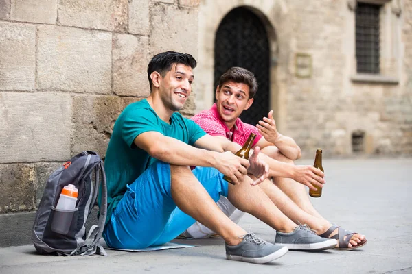 两个面带微笑的男人正在喝啤酒，在足球赛结束后聊天 — 图库照片