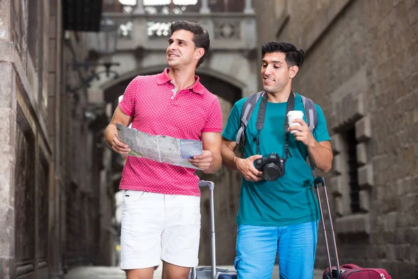 Ritratto di due amici che camminano con mappa e valigie a — Foto Stock