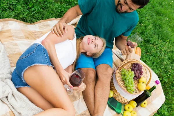 女人正躺在男朋友的腿上野餐 — 图库照片