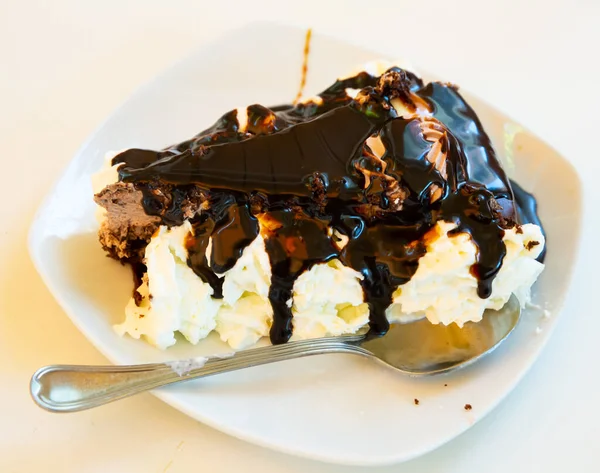 Fatia de bolo de chocolate saboroso servido em placa branca com chantilly — Fotografia de Stock