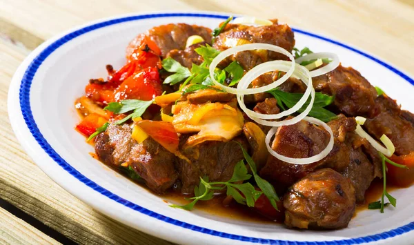 Carne di maiale fritta cotta con peperoni, funghi e cipolla sul piatto — Foto Stock