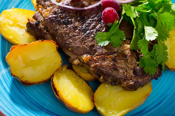 Rundsteak met gebakken aardappelen en saus op bord met groenten — Stockfoto