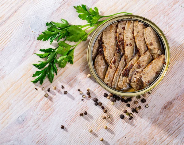 Kleine geräucherte Sardinen im Hintergrund mit grünem und schwarzem Pfeffer — Stockfoto