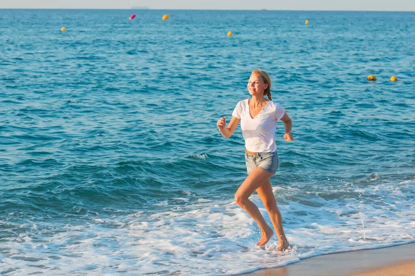Sportswoman sta facendo jogging sulla spiaggia — Foto Stock
