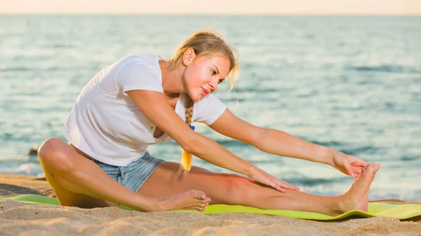 Femme en T-shirt blanc pratique l'étirement — Photo