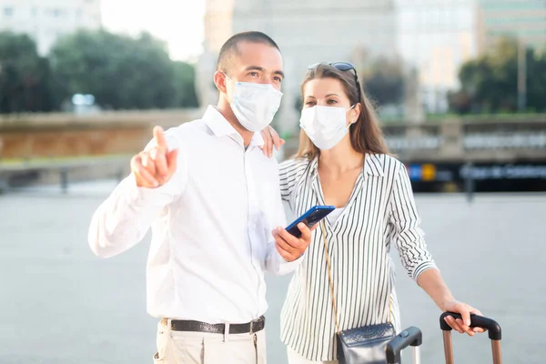 Casal de turistas em máscaras médicas visitando atrações da cidade — Fotografia de Stock