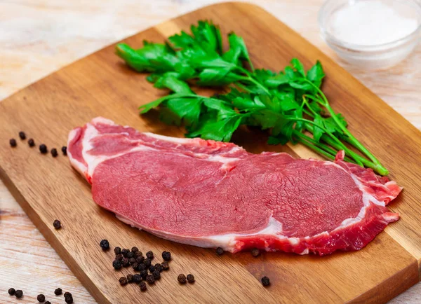 Carne de vaca não cozida bife marmoreado servido com pimenta e salley na mesa — Fotografia de Stock