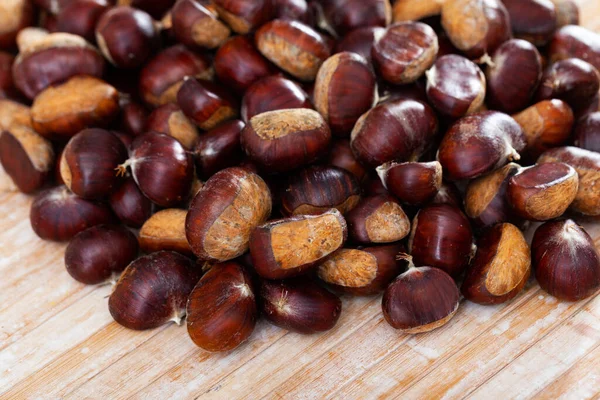 Castagne dolci commestibili non pelate su sfondo di legno — Foto Stock