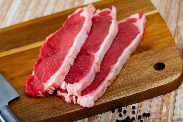 Close up of pieces of marbled beef on wooden table — Stock Photo, Image
