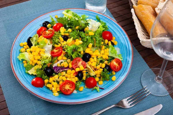 Teller mit köstlichem Salat aus Salat, Tomaten, Mais, Zwiebeln — Stockfoto