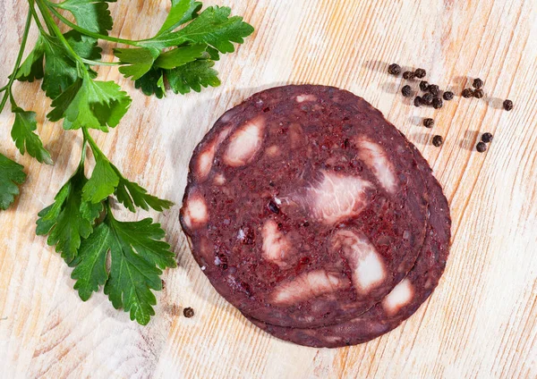 Schwarzer Pudding mit Petersilie auf Teller auf Holztisch serviert — Stockfoto