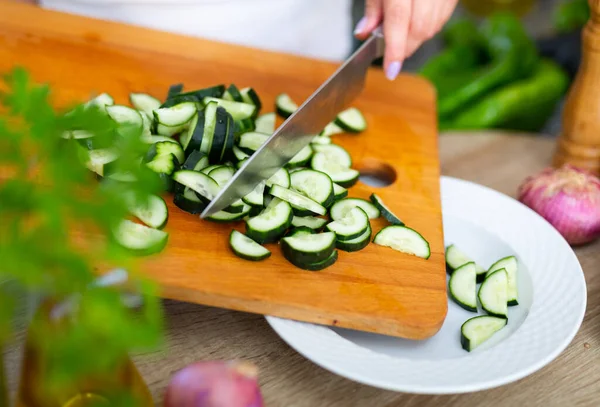 Samičí ruce krájené čerstvé okurky na zeleninový salát, — Stock fotografie
