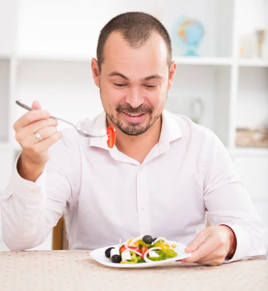 Jovem positivo comendo salada grega — Fotografia de Stock