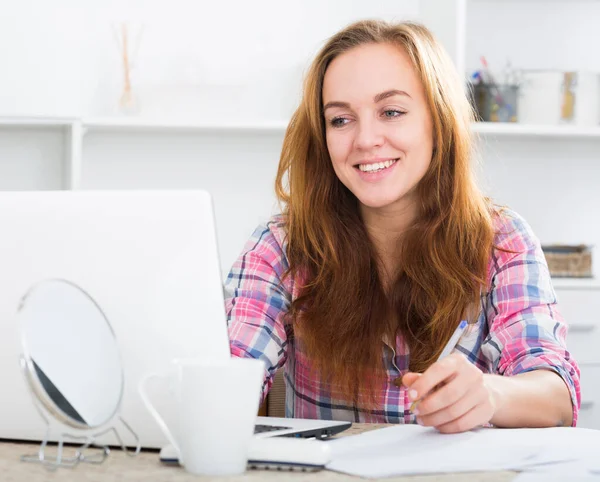 Meisje met laptop aan tafel — Stockfoto