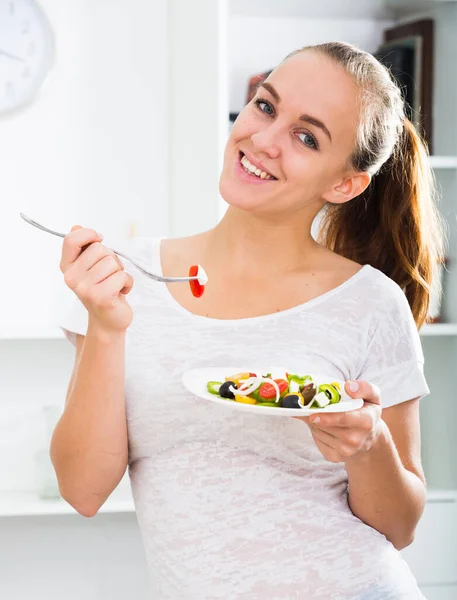 Kestane rengi saçlı, salata yiyen genç bir kadın. — Stok fotoğraf