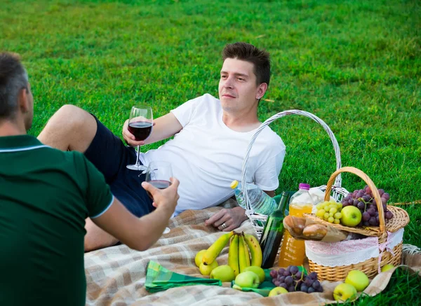 Man met vriend drinken wijn op picknick — Stockfoto