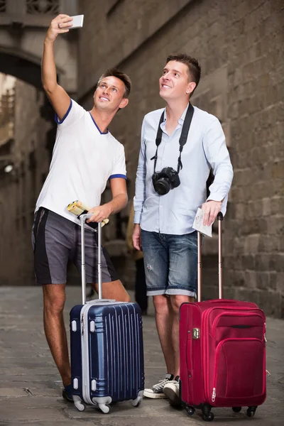 Coppia maschile turisti con bagagli facendo selfie — Foto Stock