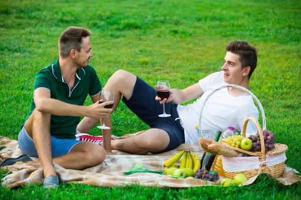 Twee mannen vrienden vrolijk tijd samen doorbrengen op picknick drinken wijn — Stockfoto