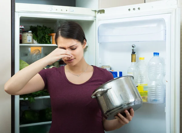 Vrouw snuffelt aan vuil voedsel — Stockfoto