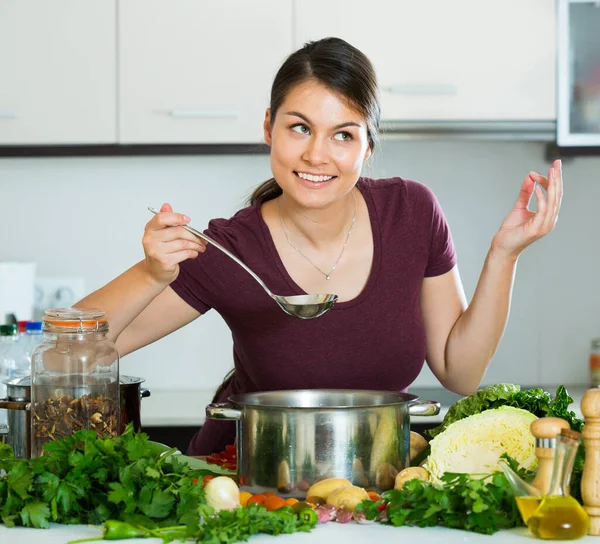 Jonge brunette koken groenten — Stockfoto