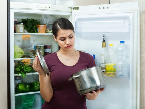 Boos en boos huisvrouw op zoek naar pot met smerig eten — Stockfoto