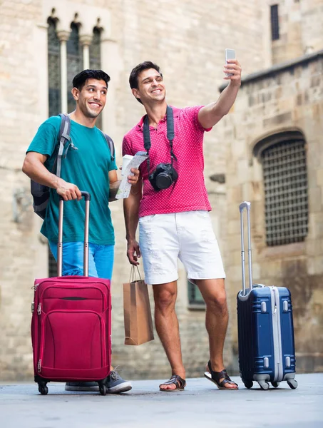 Due amici camminano con i bagagli e fanno selfie a Barcellona. — Foto Stock