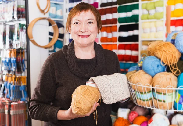 Kvinnan plockar garn i butiken — Stockfoto