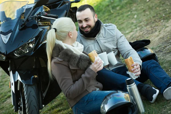 Paar posiert bei Motorrad mit Sandwiches und Kaffee — Stockfoto